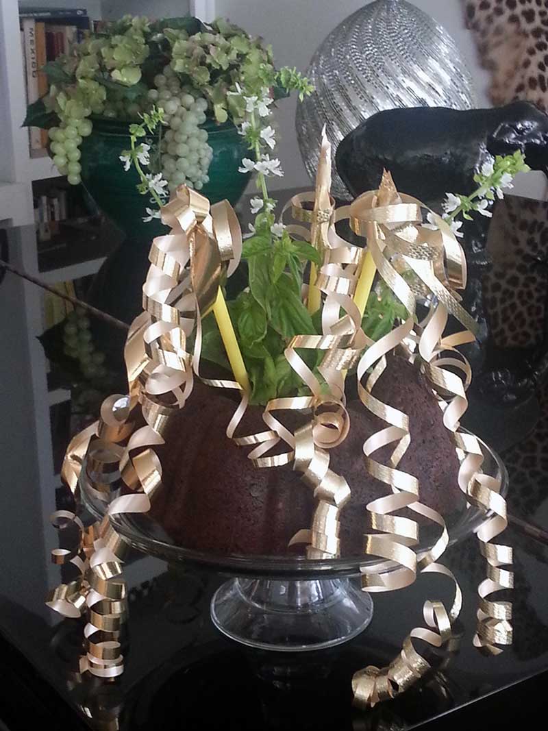 The Dump Bundt Cake in its singular glory dressed up in golden ribbons and decked out with flowering basil branches.