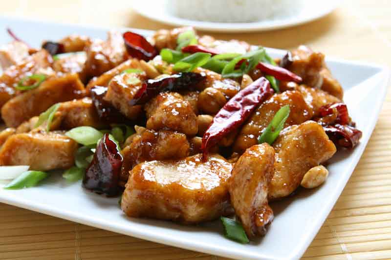 A closeup of Kung Pao Chicken served on a white plate