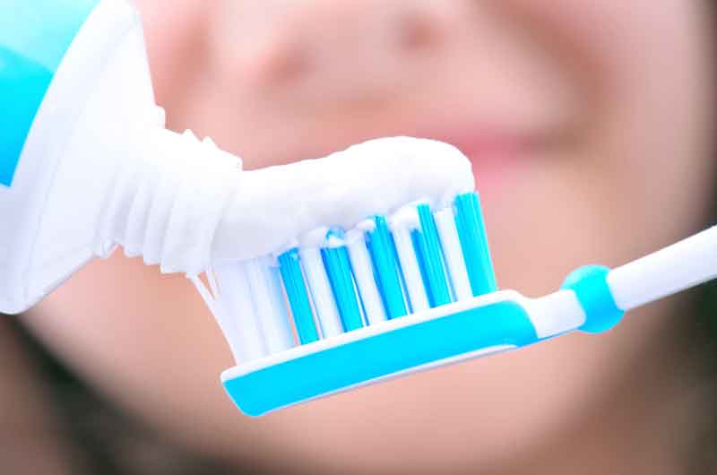 A woman prepares to brush her teeth