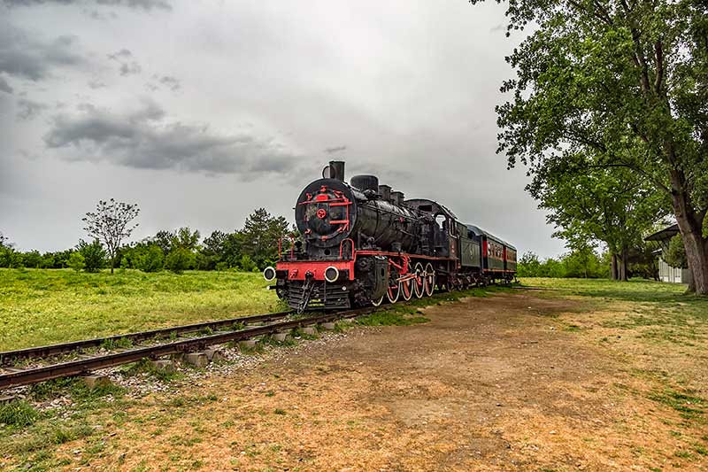 A small steam engine train on the train tracks.